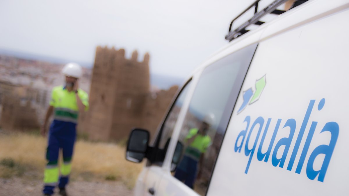 Fotografía de una de las furgonetas de trabajo de Aqualia junto a un operario.
