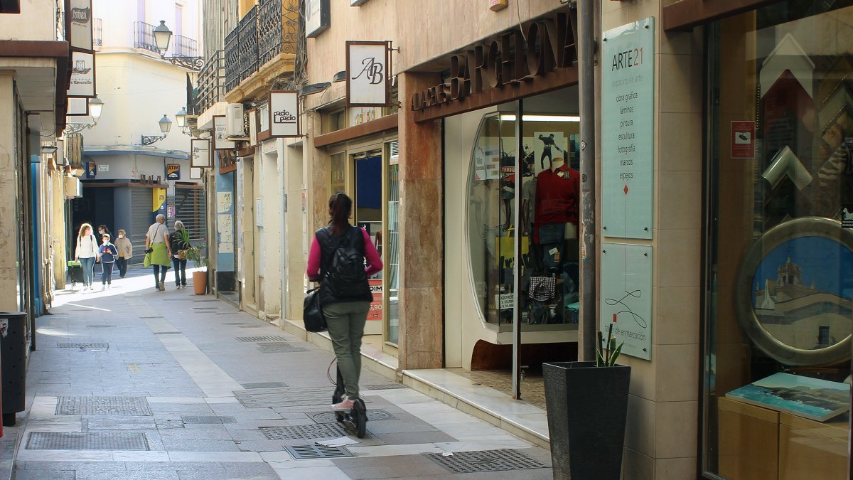 Una joven en patinete por el centro de la ciudad.