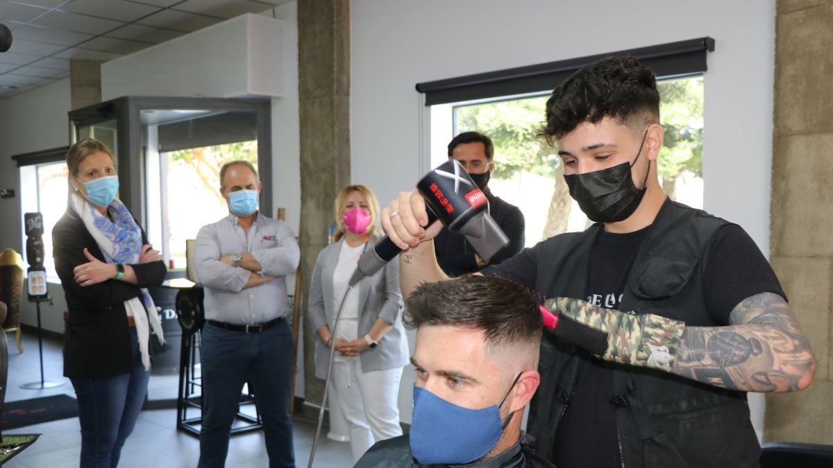 Francis peinando a un cliente ante la mirada del alcalde de El Ejido.