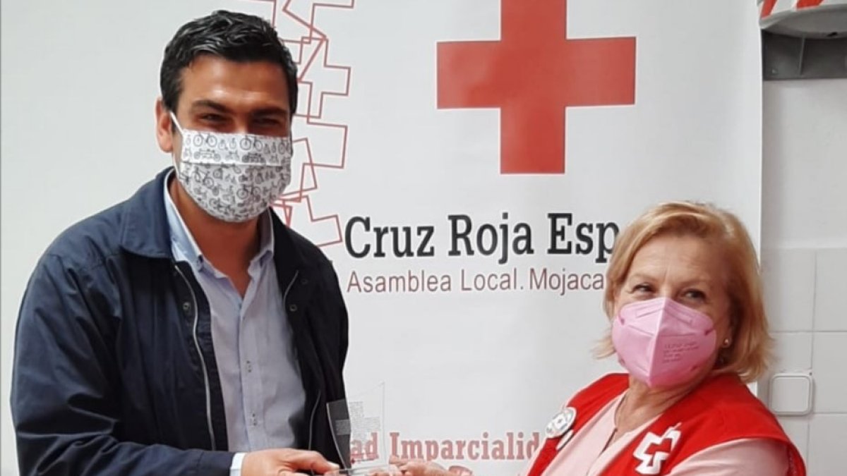El alcalde junto a la representante local de Cruz Roja tras la firma del convenio.