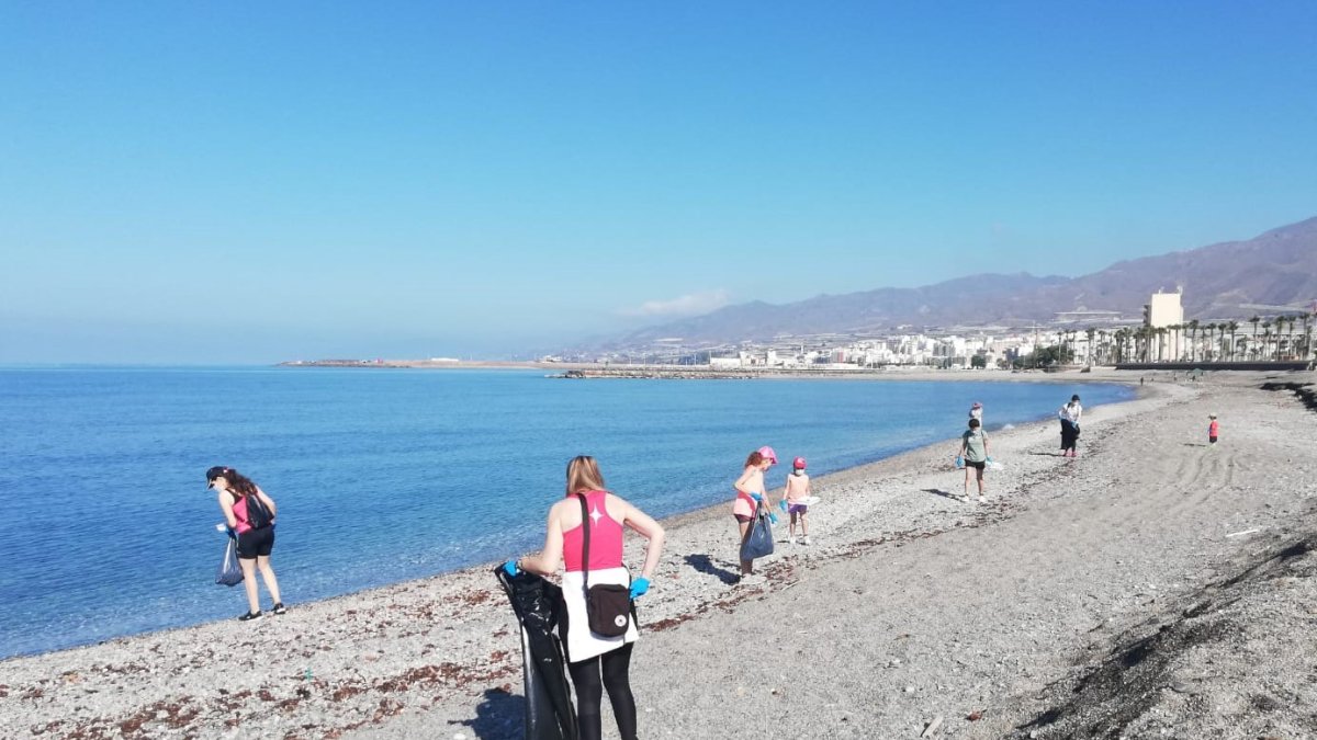 Voluntarios recogiendo residuos en la playa.