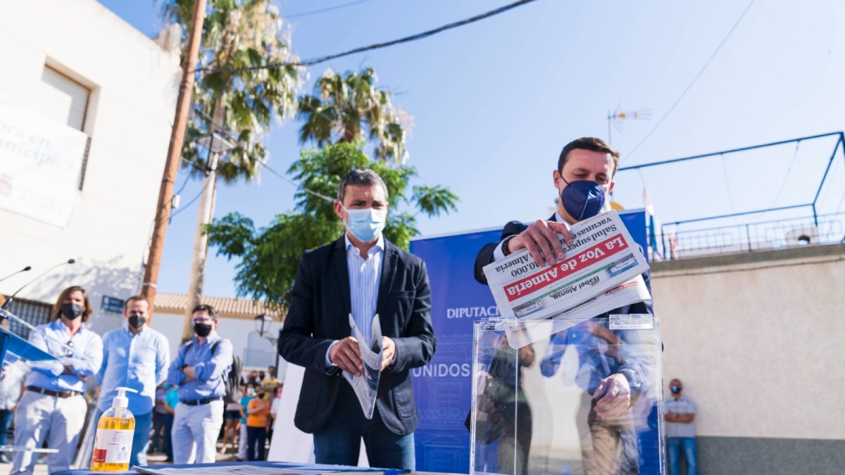 El presidente junto al alcalde introduciendo un periódico para el acto de la primera piedra.