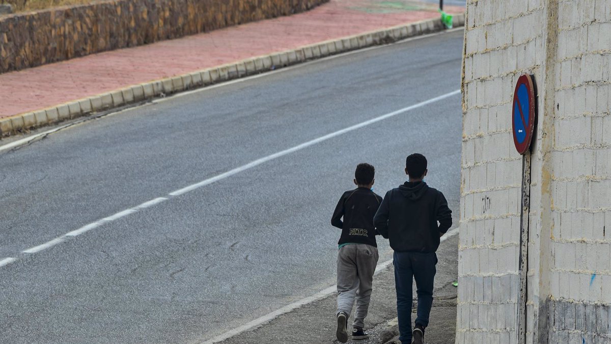 Dos menores pasean por la calle de un municipio de España.