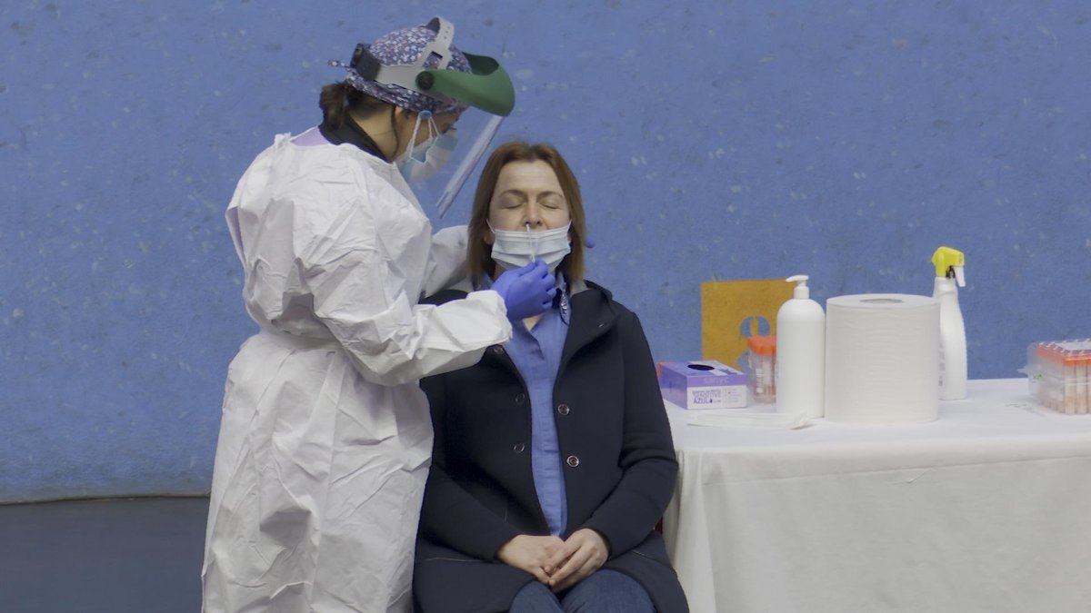 Una enfermera toma muestras a una mujer en una prueba PCR.