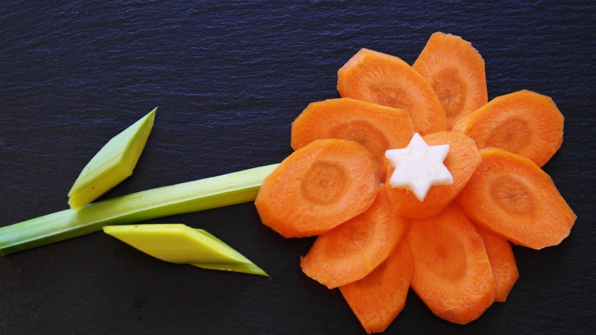 Una flor con zanahoria y puerro.
