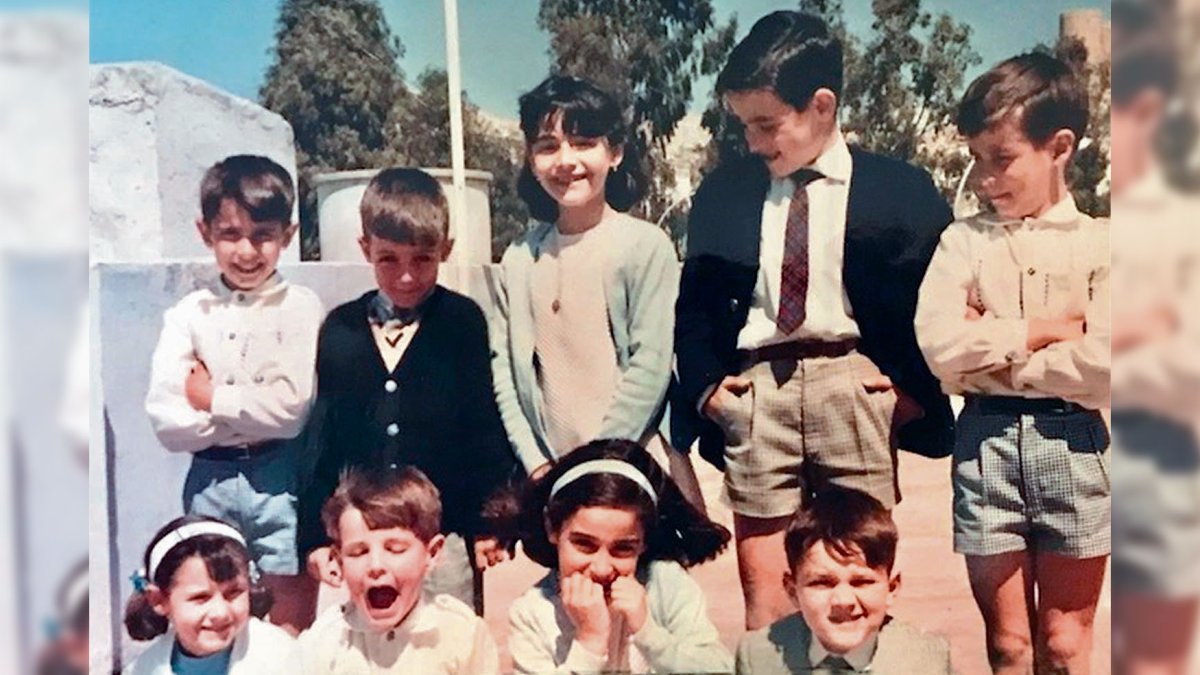 Un grupo de niños de los años 70 en un día festivo, subidos en una terrao con la Alcazaba de fondo. Iban vestidos con un rigor de adultos.
