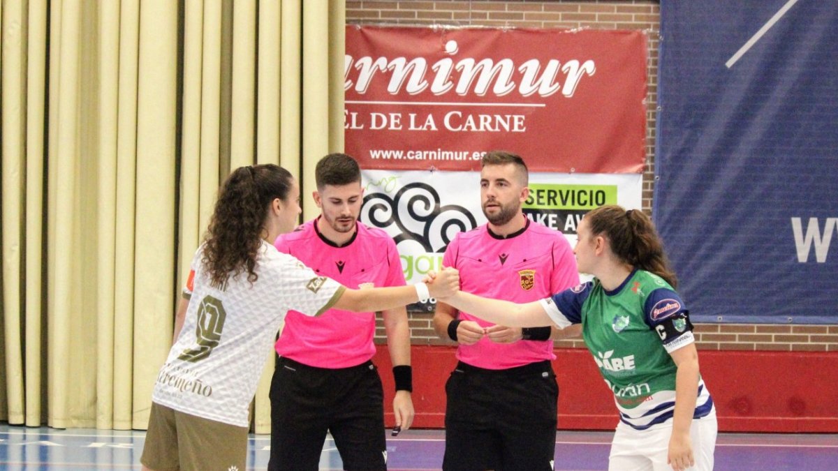 Las capitanas e saludan antes de comenzar el partido.