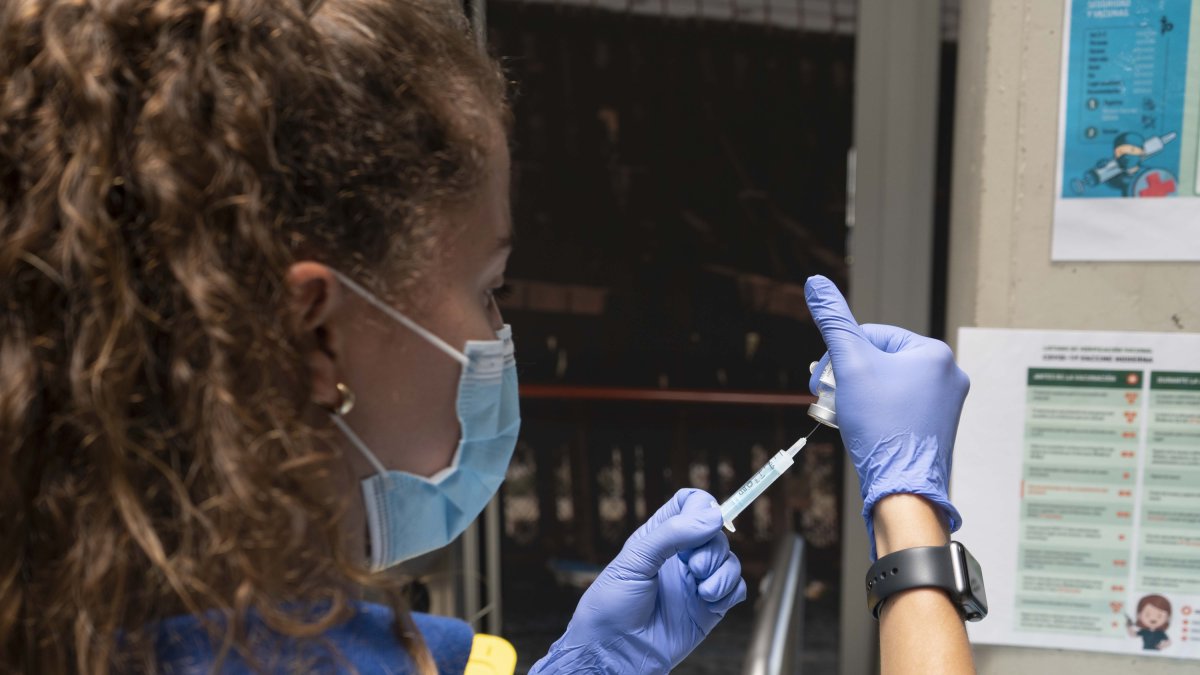 Una enfermera se prepara para administrar una dosis de la vacuna del covid.