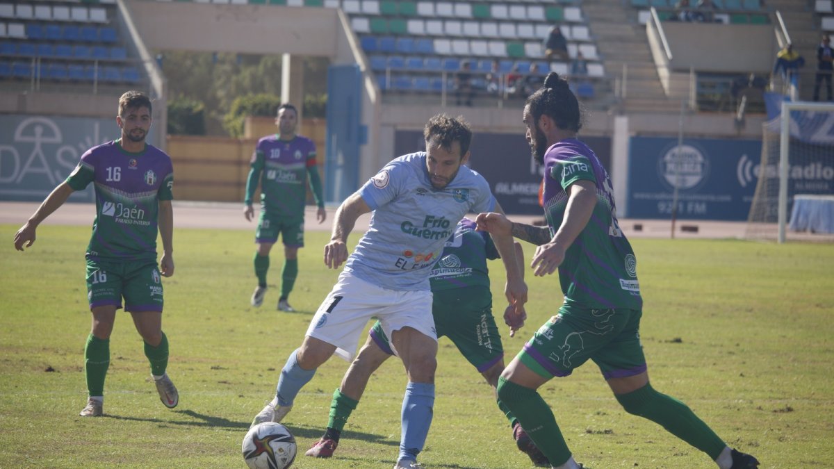 Óscar aguantando la pelota ante dos contrarios.