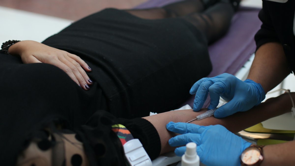 Un sanitario extrae sangre a una donante.