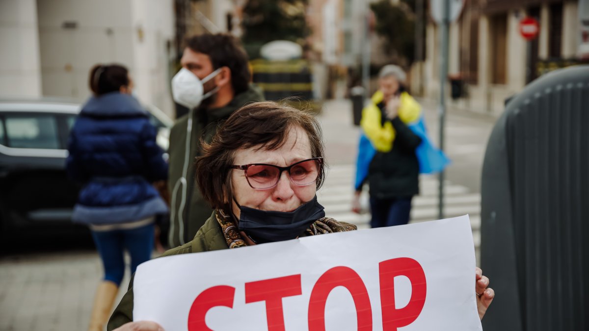 Una mujer sostiene una pancarta donde se puede leer \