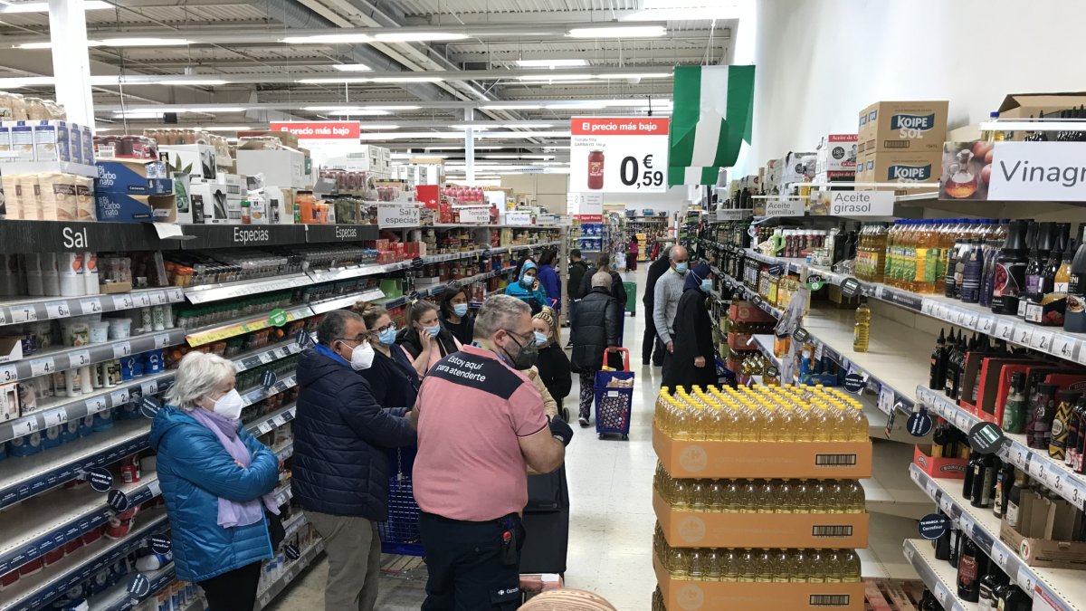 Un empleado de Carrefour repone aceite de girasol en las estanterías.