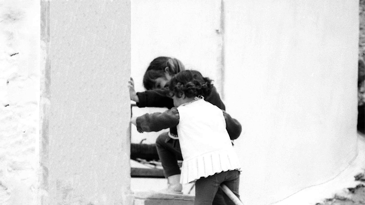 Dos niñas jugando con una escoba en el barrio de Chamberí.