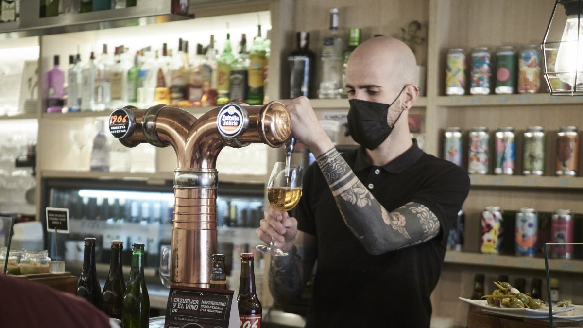 Un camarero sirve una cerveza en un bar de Pamplona.