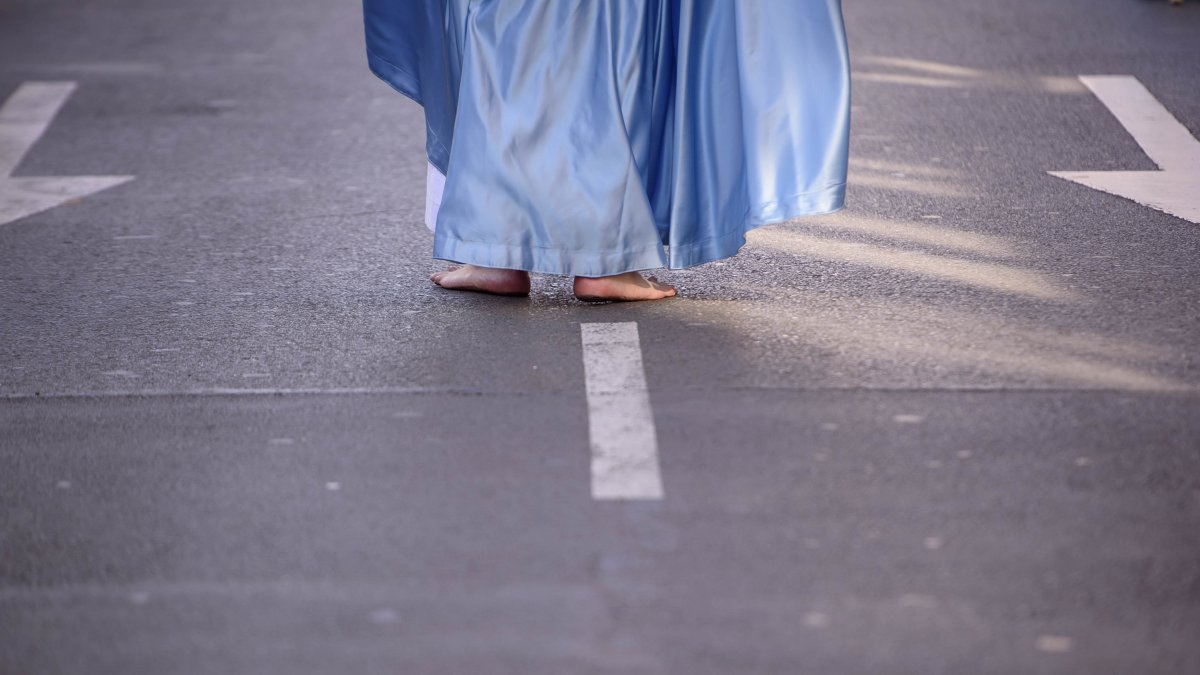 Un nazareno descalzado, realiza su estación de penitencia.