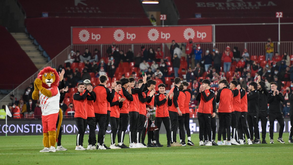 La mascota del Almería con los jugadores juveniles.