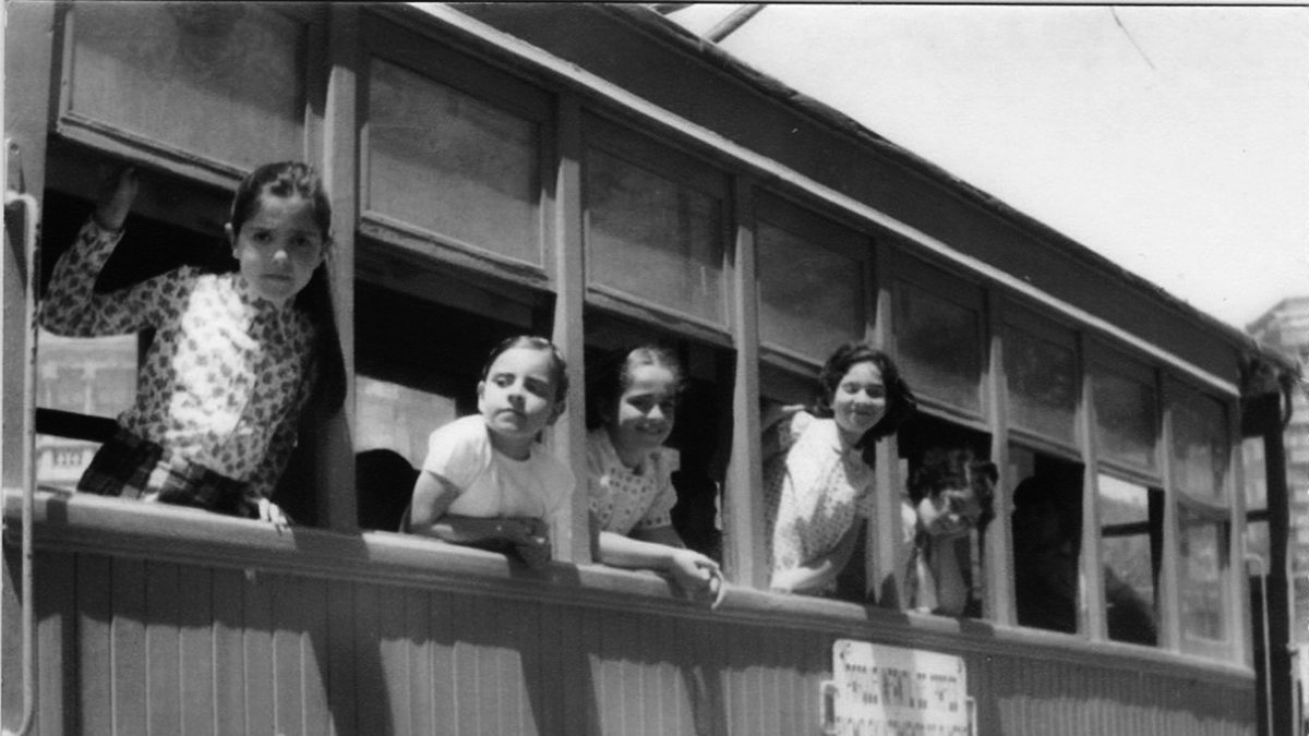 Niñas de los años 70 jugando en el tranvía de madera.