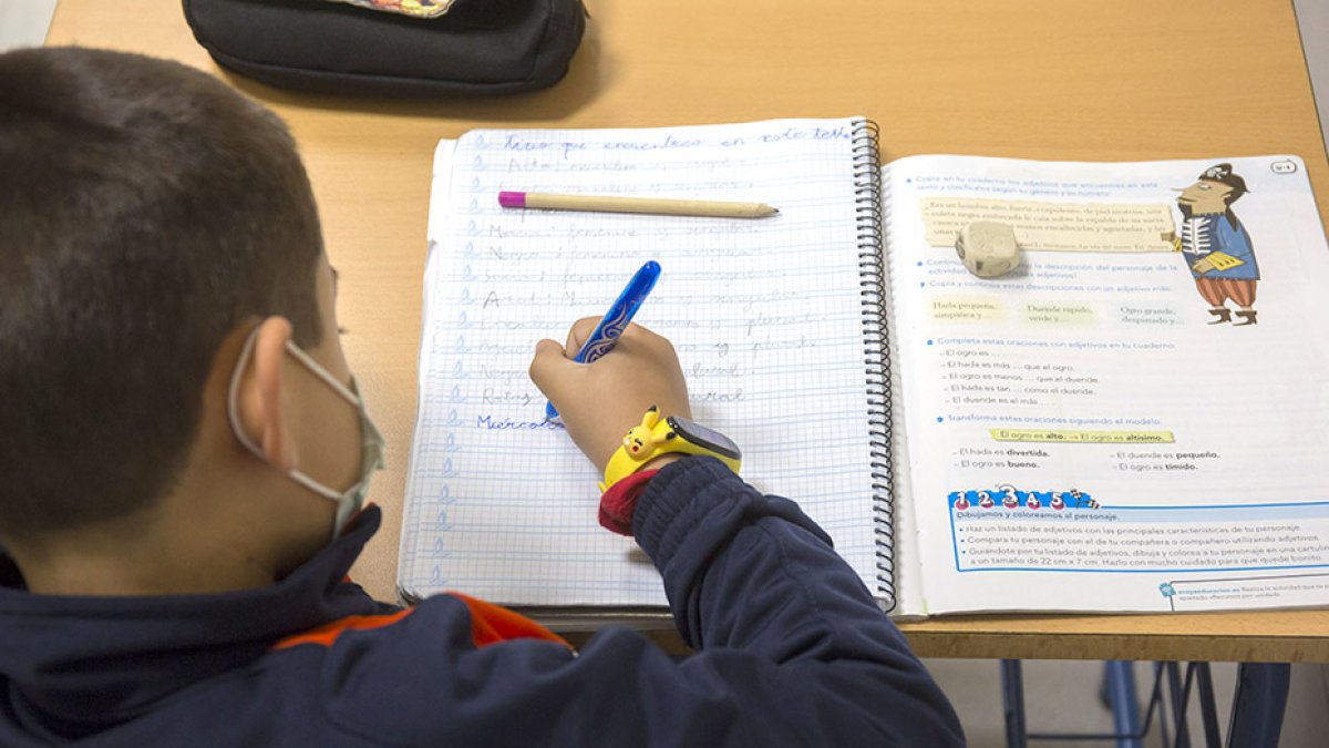 Un niño con mascarilla en clase.