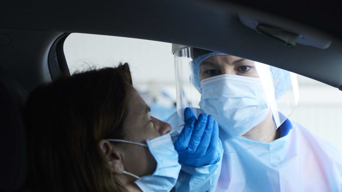 Una sanitaria le realiza la prueba PCR a una mujer en su coche.