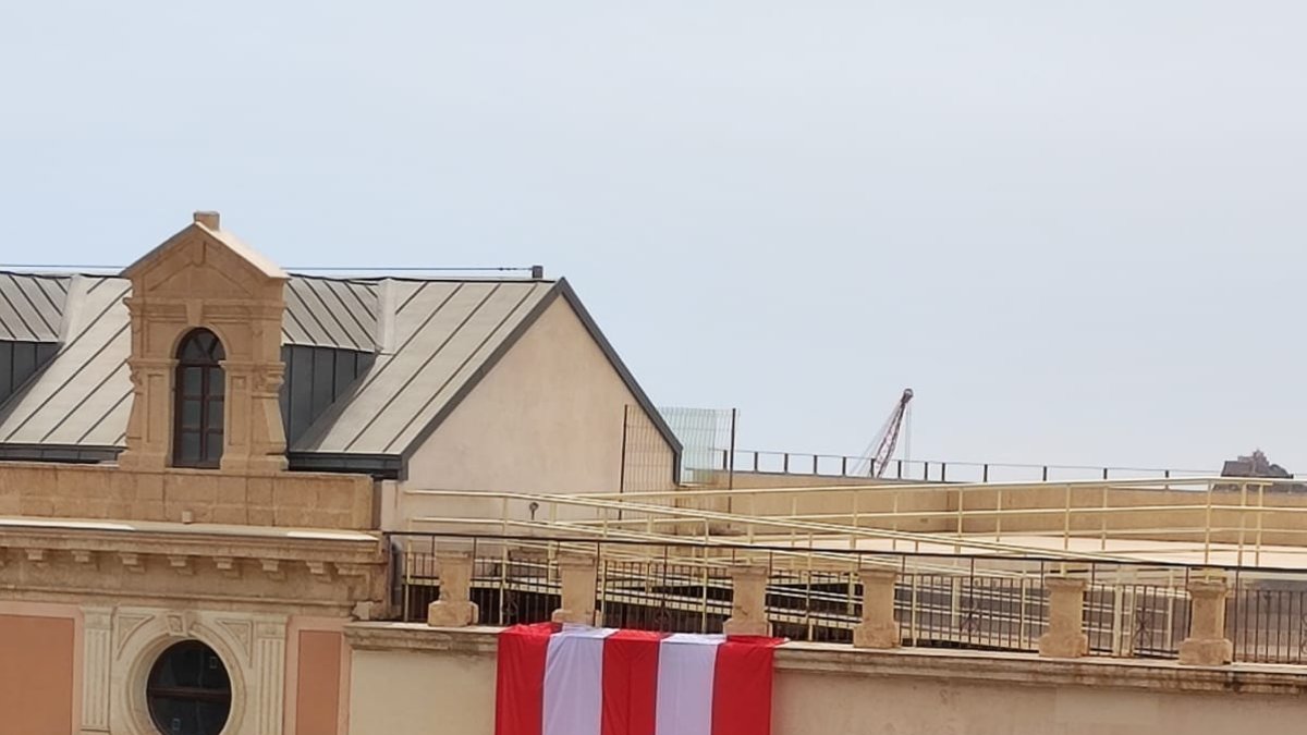 Gran bandera colgando en la fachada de la Casa Consistorial