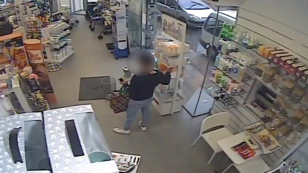 Joven llevando a cabo el acto delictivo en una farmacia.