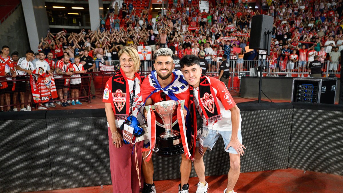 El futbolista catalán con su madre y su hermano en la hierba.