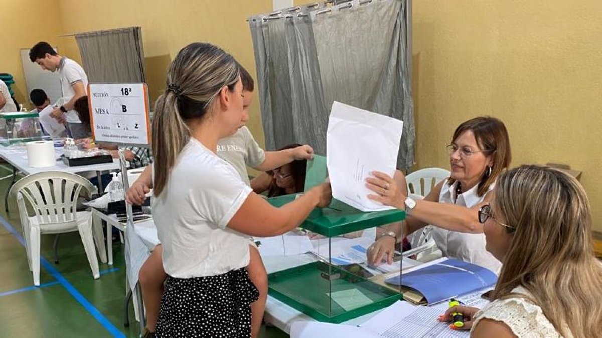 Una mujer acude con su hijo a votar.