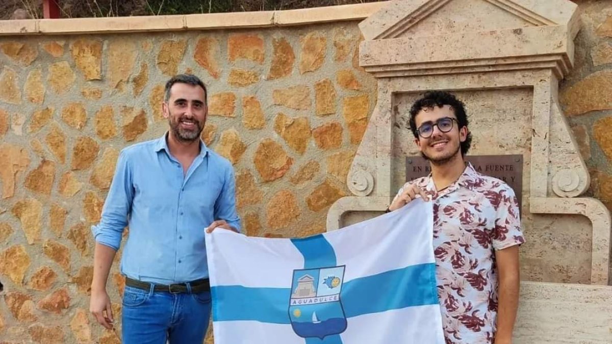 Javier García y Alejandro Golbano posan con la bandera.