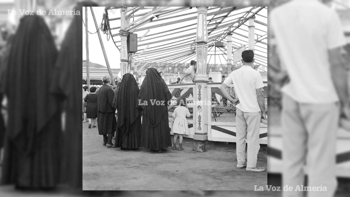 Dos monjas del Hogar delante del látigo en la feria de 1961. Junto a ellas, se puede ver a una niña con el uniforme del centro.