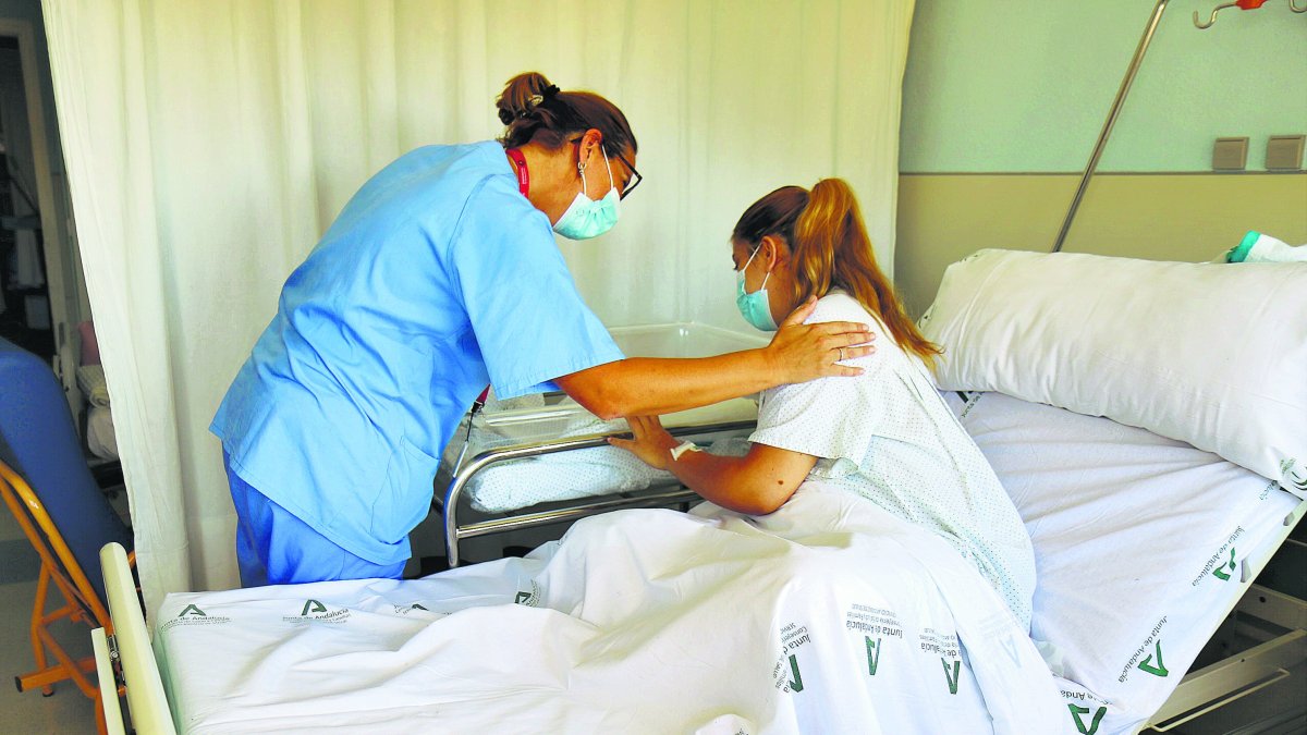 Una enfermera y una madre atienden a un bebé.