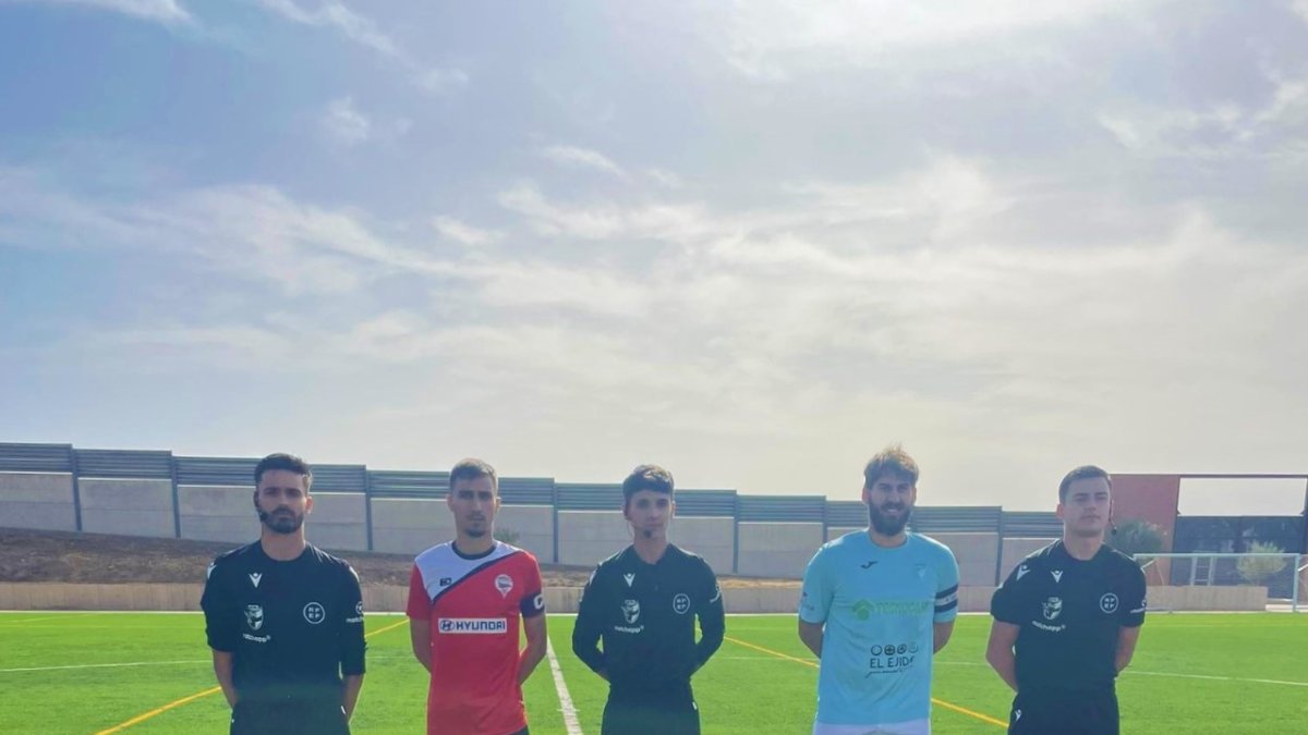 Los capitanes con el trío arbitral.