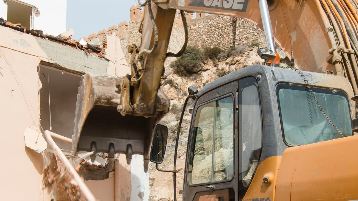 Una máquina demoliendo una vivienda