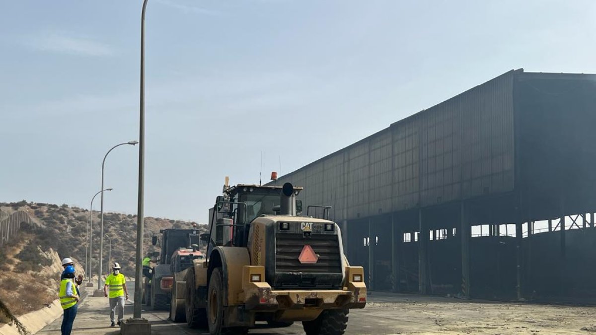 Máquinas trabajando en el desmontaje de la nave quemada en la planta