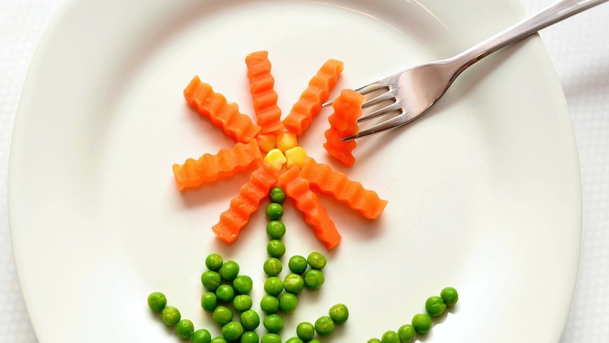 Una flor hecha con guisantes y zanahoria.