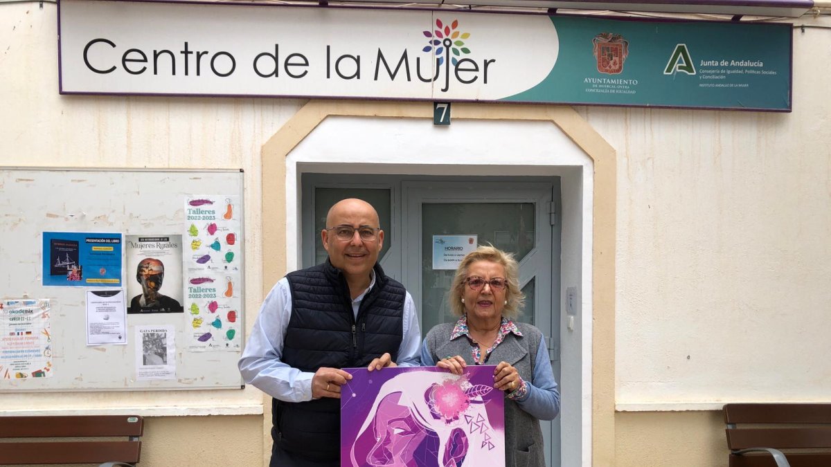 El alcalde y la concejal de Igualdad sostienen el cartel de la programación prevista por el 25-N, en Huércal-Overa.