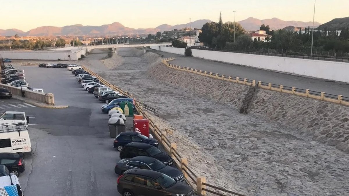 Márgenes de la rambla con coches junto al encauzamiento del canal.