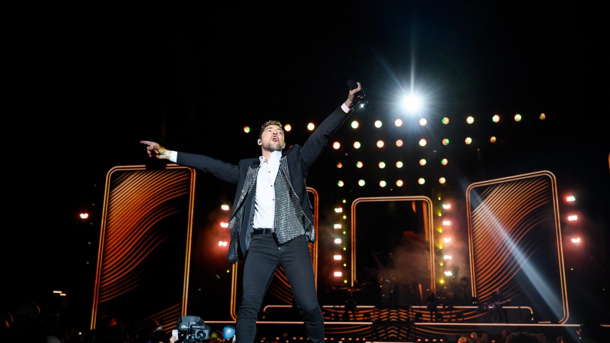 Miles de personas disfrutan de un concierto único por el 20 aniversario de David Bisbal sobre el escenario.