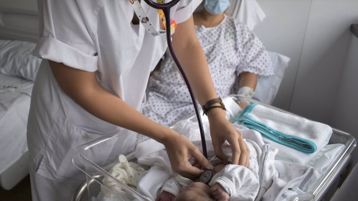 Un menor atendido por una profesional en un hospital.