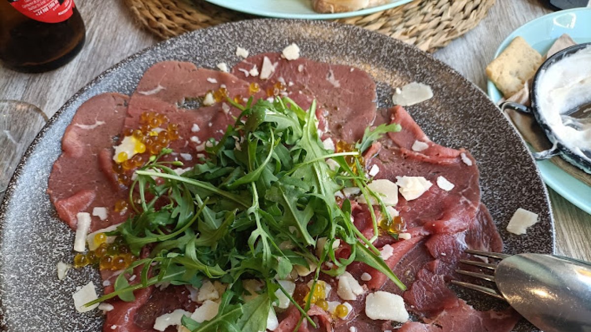Carpaccio trufado de buey con parmesano y perlas de aceite.