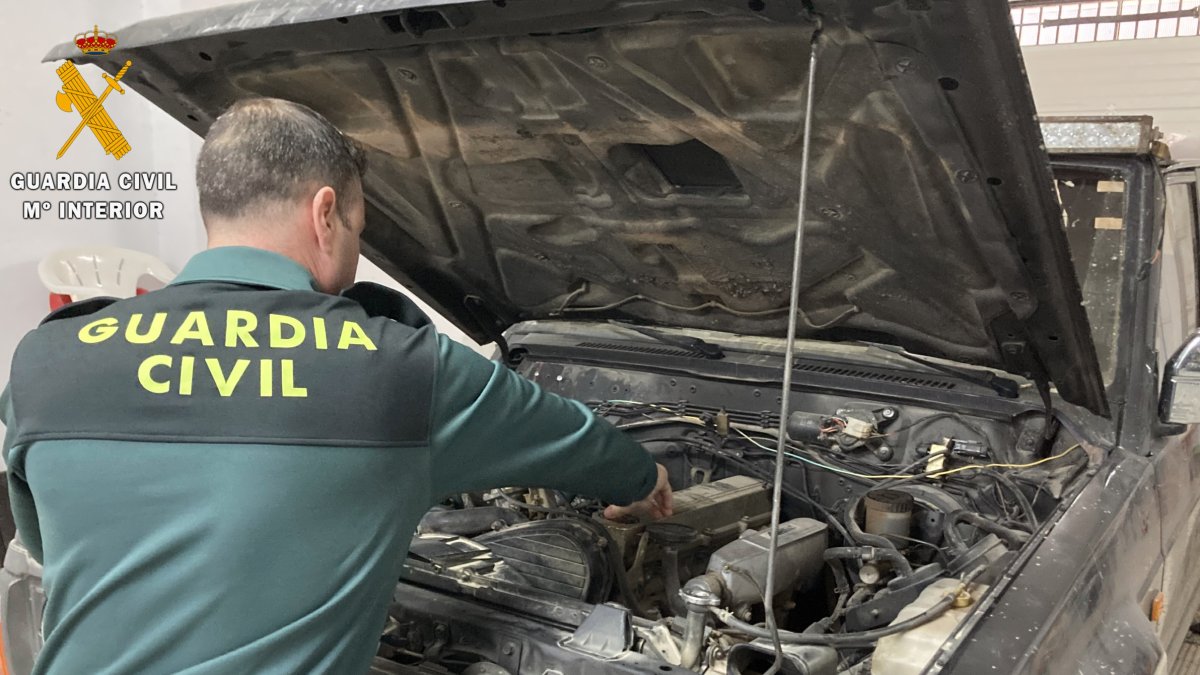 Un guardia civil examina el coche robado en Granada.