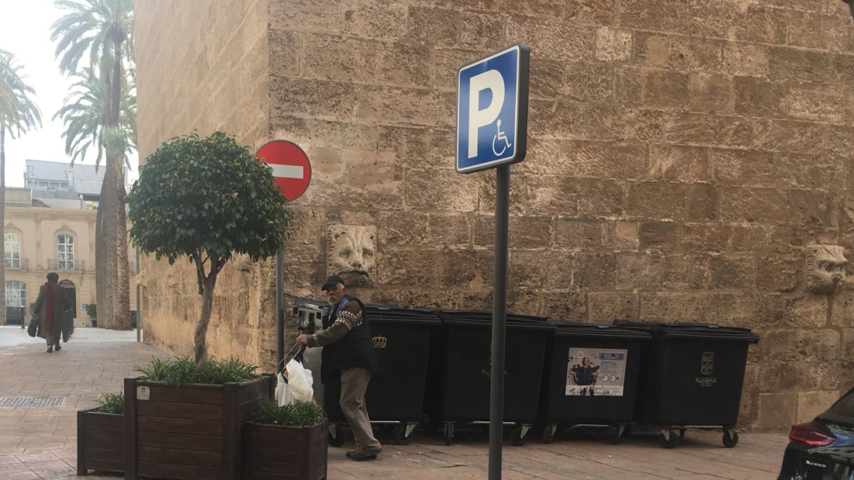 Imagen de la fachada de la torre del campanario de la catedral con los contenedores de basura.