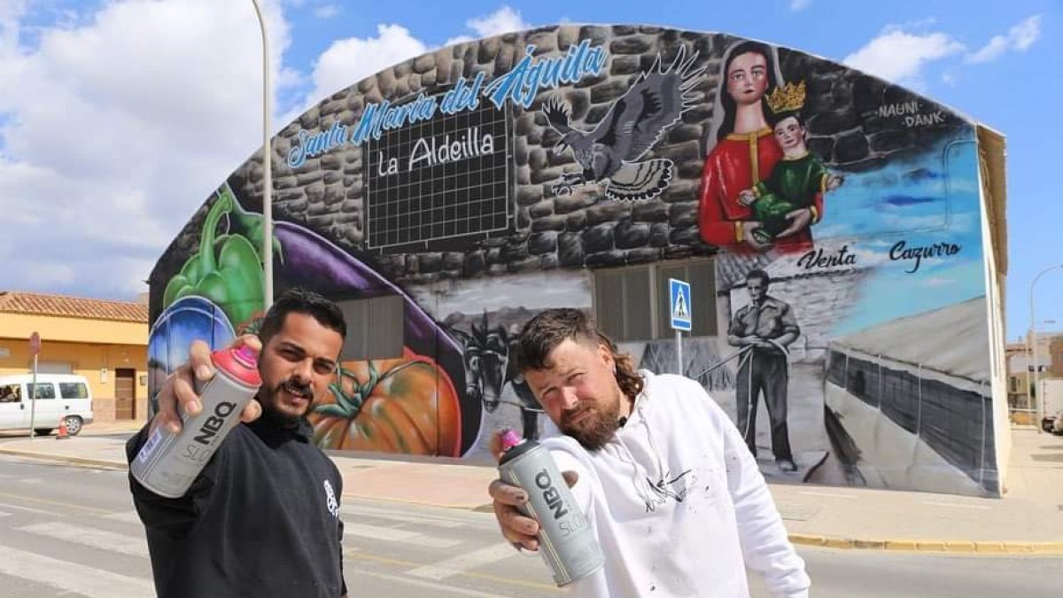 Los artistas Dank y Nauni posan con el mural de fondo.