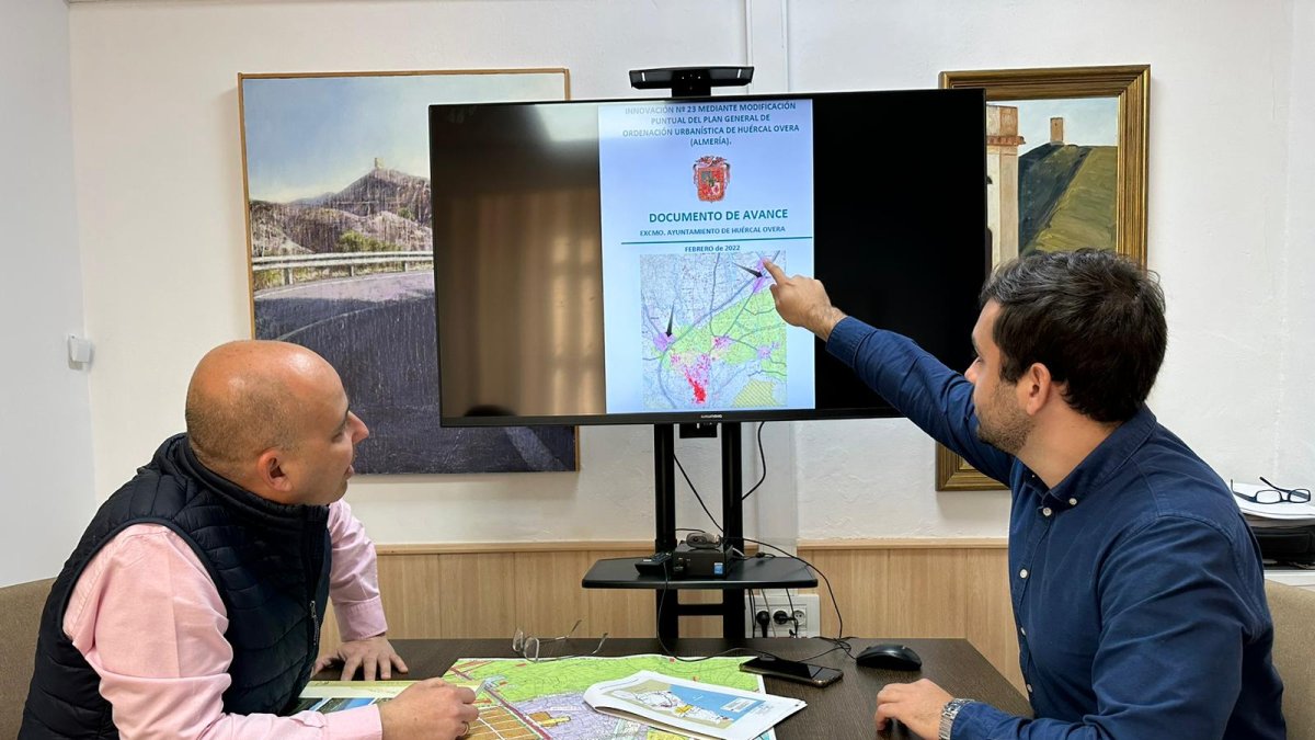 Alcalde y concejal estudiando el avance urbanístico.