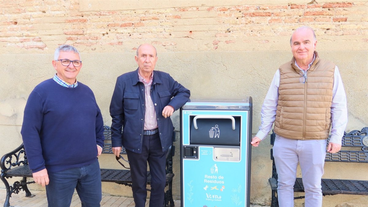 El concejal de Servicios Públicos y responsables de la empresa Raga Medioambiente, junto a una papelera inteligente en la plaza