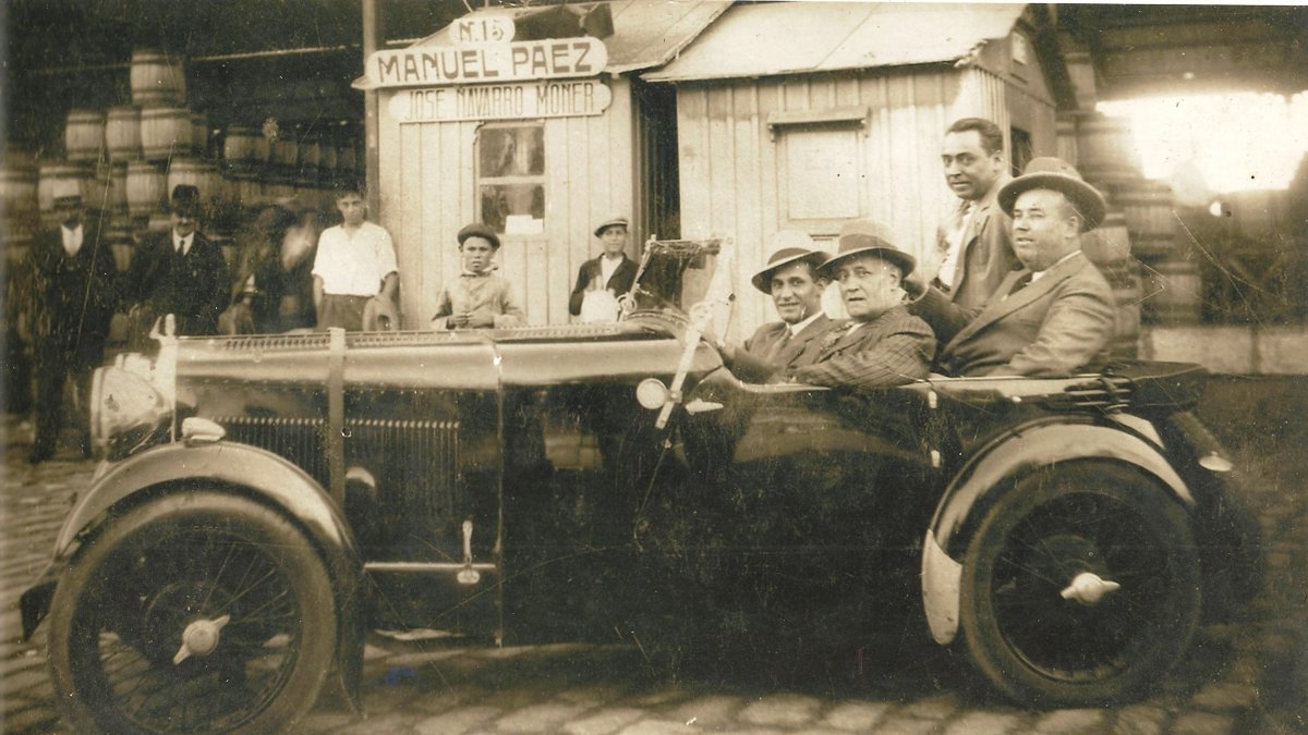 En la foto de 1930, montados delante en un Ford, José Navarro Moner y su padre José Navarro Corbató. Detrás, un empleado y con sombrero, Manuel Páez
