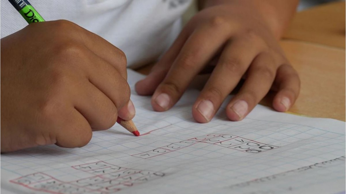 Un alumno realiza sus tareas en el colegio.