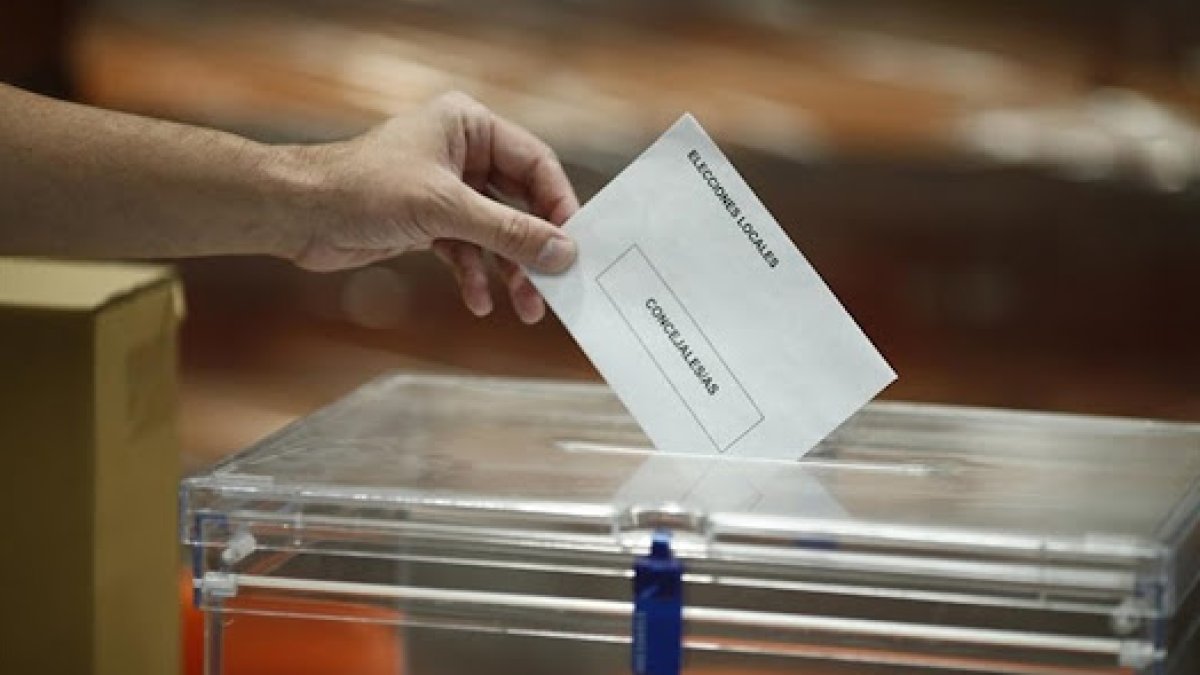 Una persona depositando su voto en la urna.