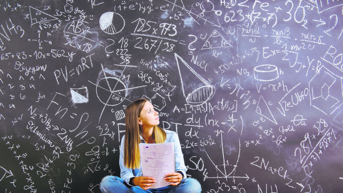 Una joven ante una pizarra repleta de cálculos matemáticos