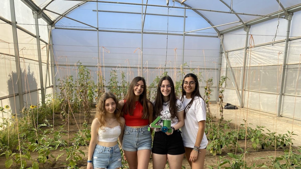 Las cuatro alumnas con el prototipo diseñado por ellas en un invernadero.