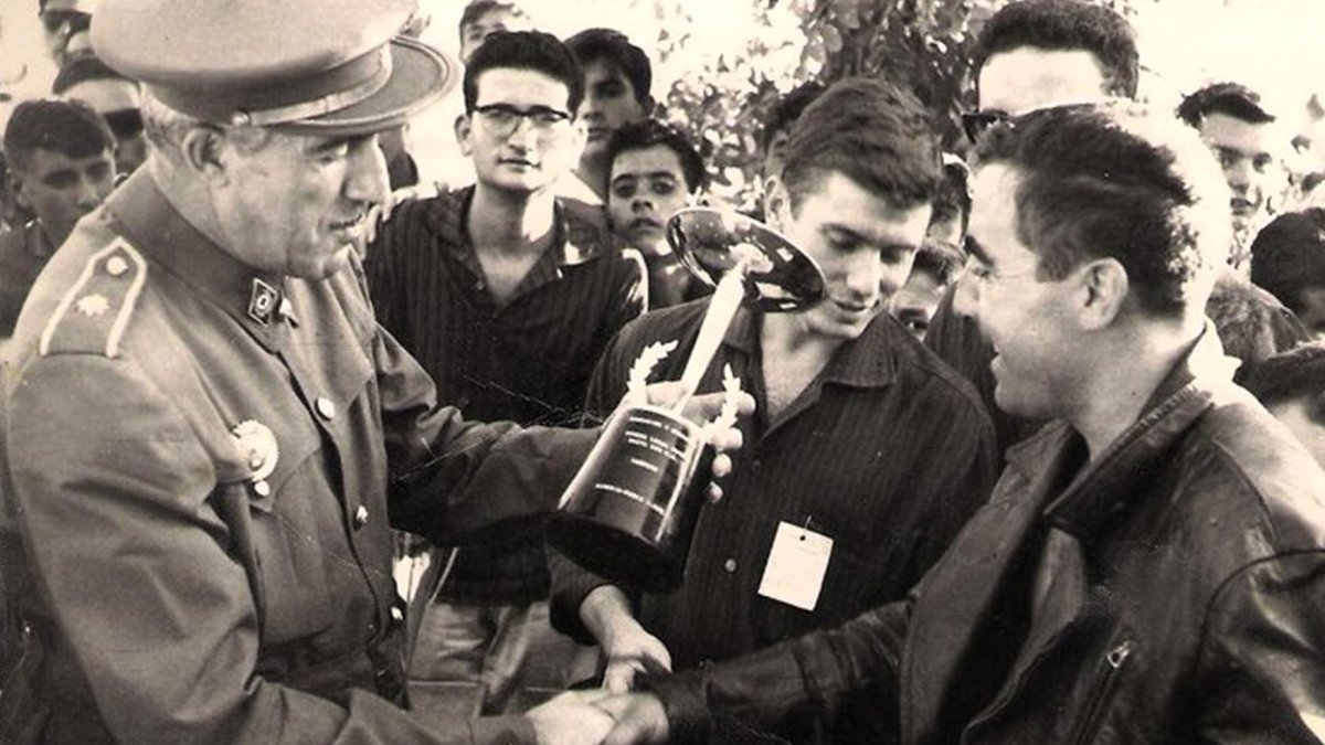 Carlos Escaso recibiendo una copa después de haber ganado una carrera.